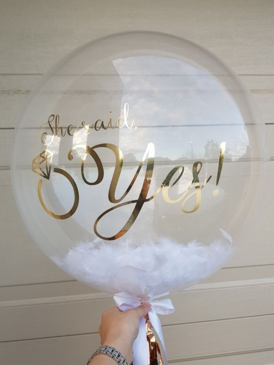 Бабл з білим пір’ям і написом She said yes